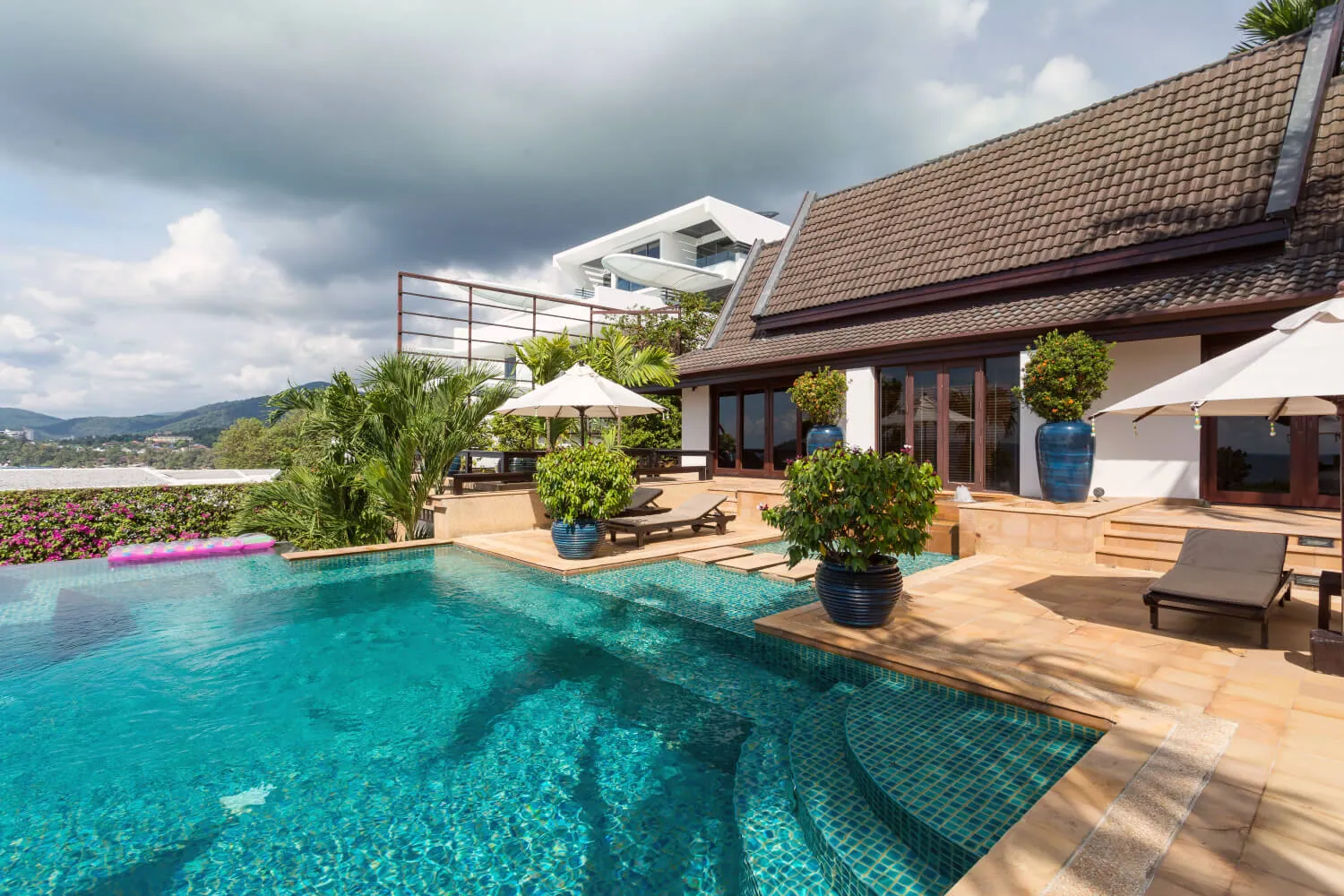 Sun loungers on the sandstone deck beside the pool
