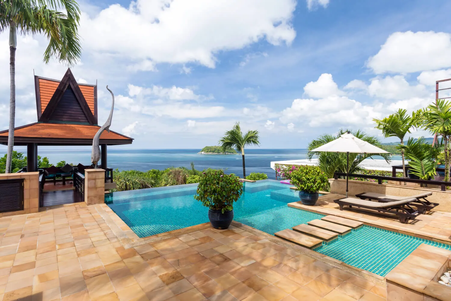 The full sandstone pool terrace with the sala and parasol