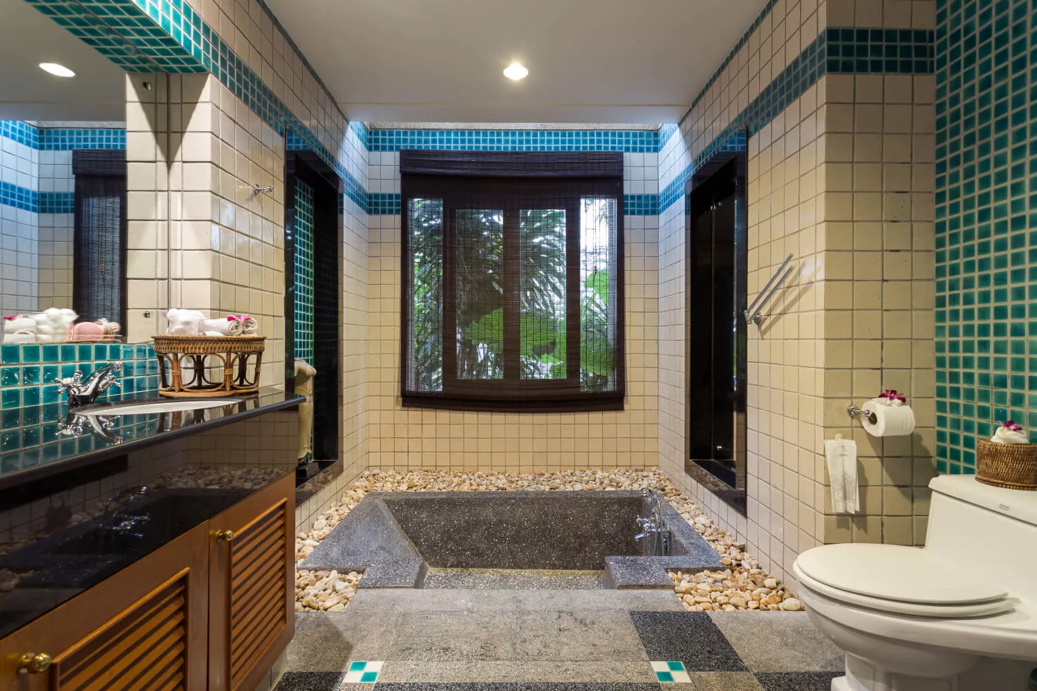 A sunken stone bath with mosaic tiling