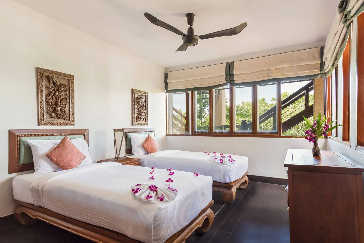 A twin bedroom with carved Thai panels